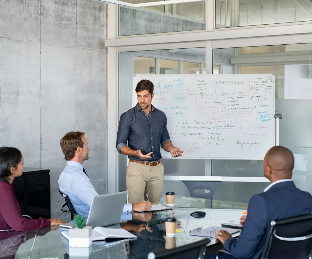 Mitarbeiter besprechen ein Projekt am Whiteboard