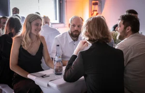 Mitarbeiter, Freunde und Familie an einem Tisch