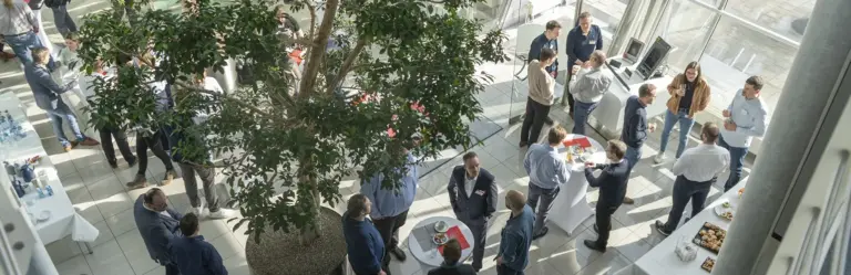 Kunden und Kundinnen tauschen sich mit H+K Mitarbeitenden im Foyer aus