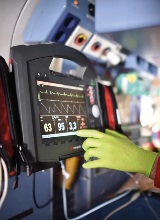 Mensch bedient Patientenmonitor im Hubschrauber