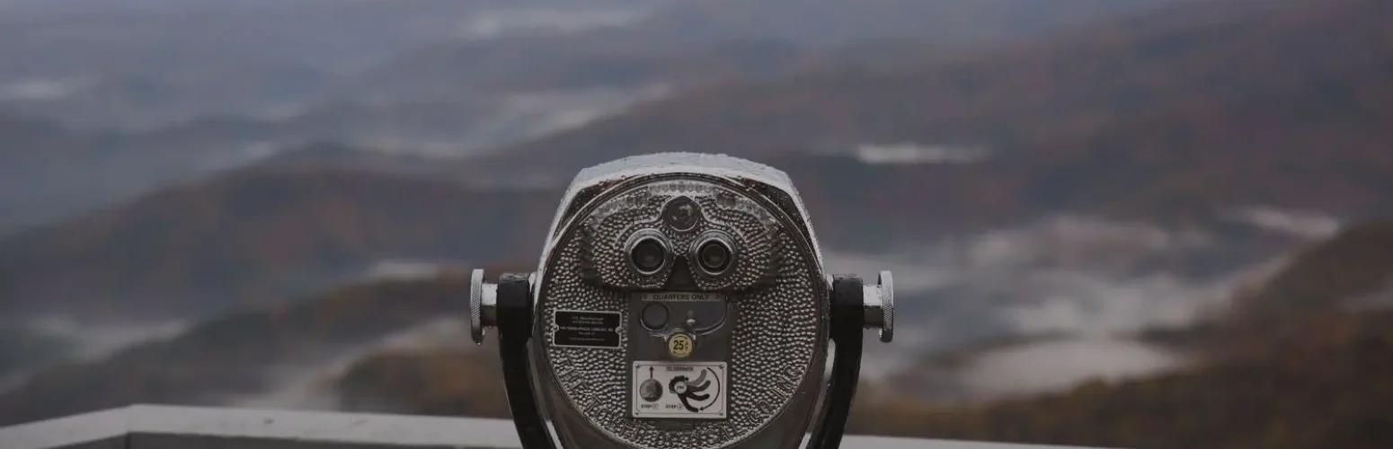 Fernglas mit Bergen im Hintergrund